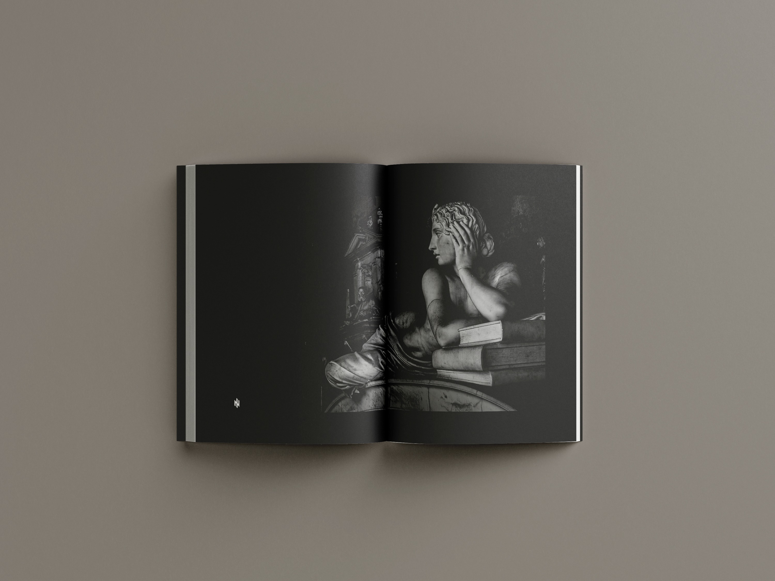 Full-bleed spread with classical sculpture photograph in dramatic lighting